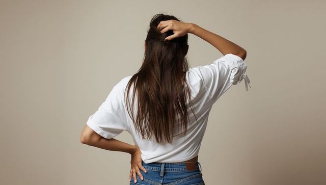 Fashionable woman showcasing style with confident pose in studio