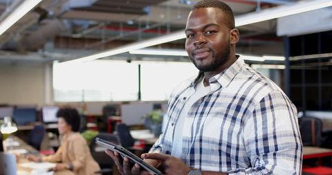 Casual businessman in contemporary office using tablet