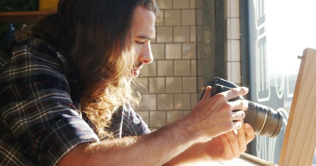 Male Photographer Using Camera in Brightly Lit Room with Long Hair - Download Free Stock Images Pikwizard.com