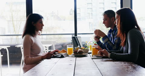 Colleagues Discussing Ideas Over Breakfast Meeting