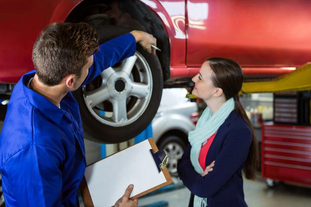 Mechanic showing customer the problem with car at the repair garage