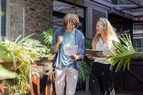 Diverse Coworkers Celebrating Team Success in Green Office Space