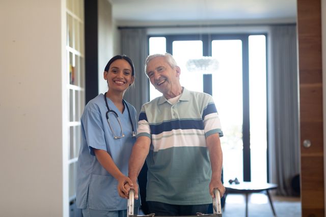 Portrait of caucasian smiling female doctor assisting senior man in walking with walker at home. Unaltered, physical therapy, healthcare, retirement, helping, disability, treatment and recovery.