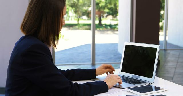 Businesswoman Working on Laptop in Office with Tablet - Download Free Stock Images Pikwizard.com