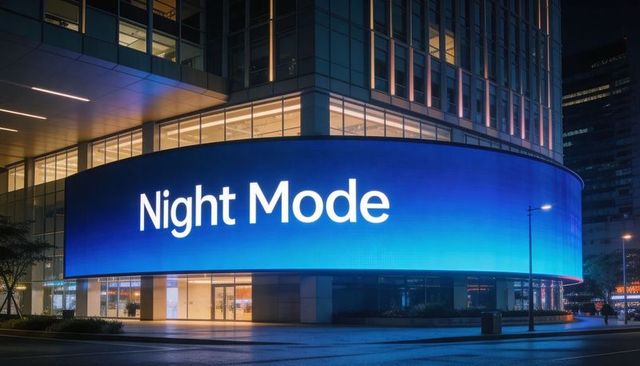 Curved led billboard displaying night mode blue gradient on downtown glass office facade