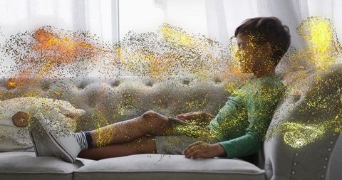 Dreamlike golden particle swirl surrounding relaxed boy reclining on tufted chaise sofa