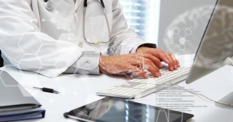 Male Doctor Typing on Computer Keyboard in Clinical Office