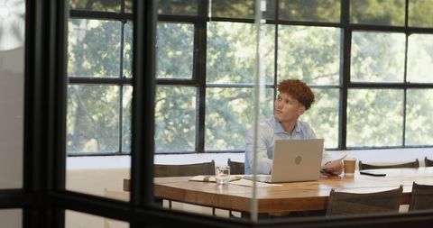 Businessman contemplating work decisions at office desk