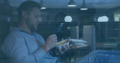 Businessman relaxing with late-night pasta meal in office