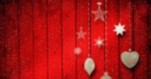Blurry Christmas Decorations on Red Wooden Background with Falling Snow