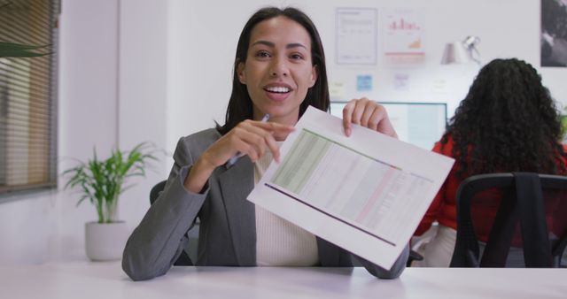Confident Businesswoman Presenting Document in Modern Office - Download Free Stock Images Pikwizard.com