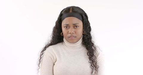 Serious Young Woman with Long Curly Hair in Studio Portrait