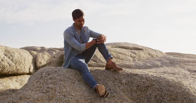 Man Relaxing on Rock Using Smartphone at Outdoor Scenic Spot - Download Free Stock Images Pikwizard.com