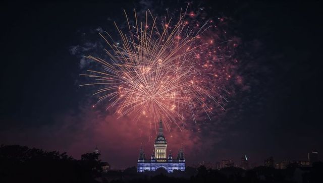 Celebratory Fireworks Exploding Above Massive Clock Tower at Night