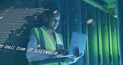 Technician Analyzing Data Amidst Servers in Industrial Setting