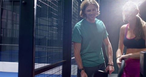 Friends enjoying recreation at padel court in sportswear