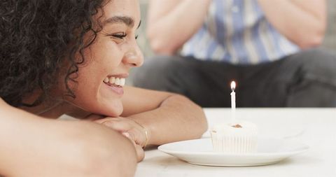 Happy Woman About to Blow Candle on Birthday Cupcake