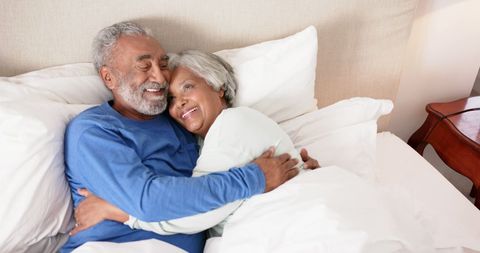 Senior Couple Embracing with Joy and Relaxation in Bedroom