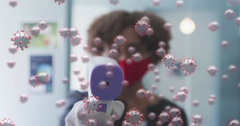 Digital representation of COVID-19 particles combined with a woman using a digital thermometer while wearing a face mask. This symbolizes health and safety strategies during the pandemic, reflecting measures taken to prevent virus spread. Useful for illustrating articles about health precautions, pandemic impacts, and educational materials regarding infection prevention.