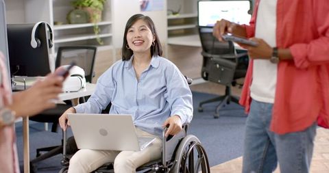 Smiling Woman in Wheelchair Collaborating in Office Meeting