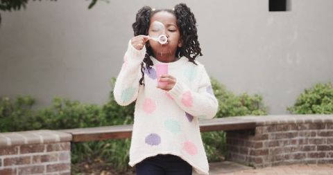 Young Girl Blowing Bubbles in Outdoor Leisure Setting