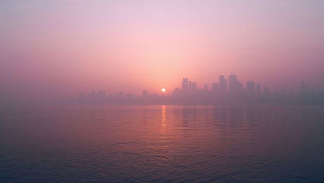 Tranquil skyline at sunrise reflecting over serene waterfront