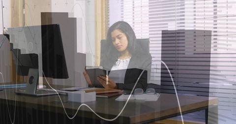 Professional woman analyzing reports in modern office