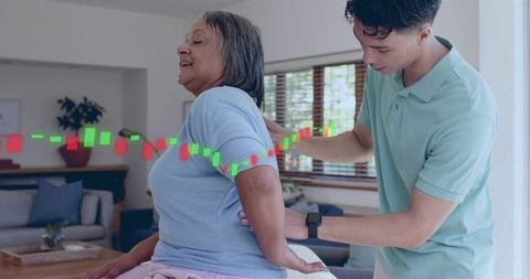 Caregiver assisting senior woman with back support at home with candlestick health overlay