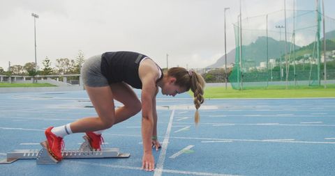 Female Athlete Preparing at Starting Block on Track - Download Free Stock Images Pikwizard.com