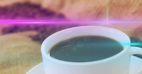 White cup black coffee with pink and cyan light flares, cozy bokeh closeup