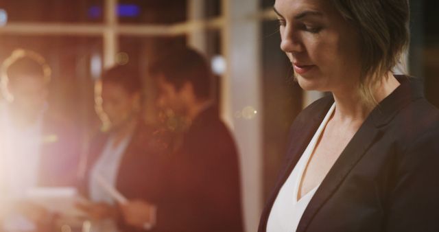 Businesswoman Contemplating at Office Meeting with Colleagues in Background - Download Free Stock Images Pikwizard.com