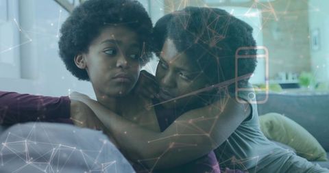 Comforting mother embracing teenage daughter on couch with smartphone connectivity overlay