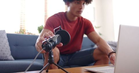 Man Setting Up Podcast Equipment in Modern Home Studio