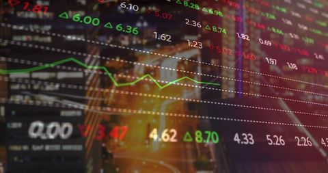 Digital Stock Market Data Over Cityscape at Night