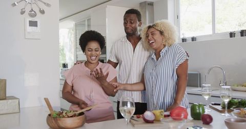 Friends Sharing Joyful Moments While Meal Preparing in Modern Kitchen