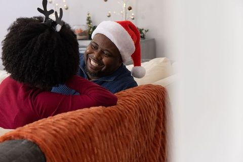 African american couple sharing cozy holiday moment wearing santa hat and reindeer antlers