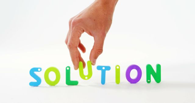 Hand Arranging Colorful Plastic Letters Forming Word 'Solution' - Download Free Stock Images Pikwizard.com