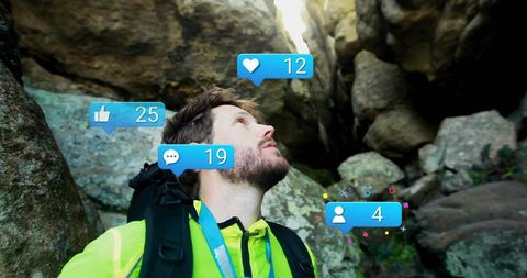 Hiker gazing up narrow rock crevice with floating social media notification icons