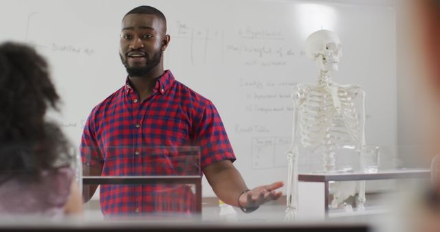 This image is ideal for educational materials, university brochures, academic articles, or online courses related to medicine and anatomy. It showcases a professor teaching students about human anatomy using a skeleton model, which is an effective visual aid for engaging and informative content.