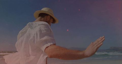 Carefree moment on scenic beach with man in straw hat and white shirt