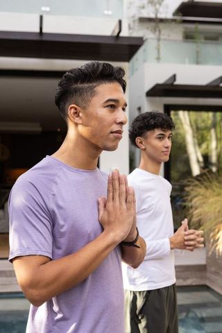 Male Friends Meditating Together in Contemporary Outdoor Space