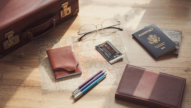 Sunlit vintage travel essentials on wooden tabletop for classic trip planning and packing
