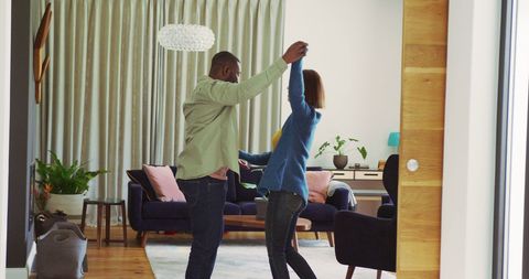 Joyful Couple Dancing Together in Cozy Living Room