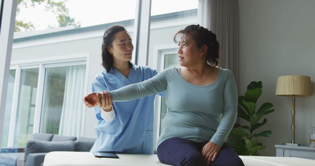Female physiotherapist helping patient with rehab exercises in modern clinic. Suitable for use in healthcare websites, physical therapy promotional materials, medical services advertising, and rehabilitation program brochures.
