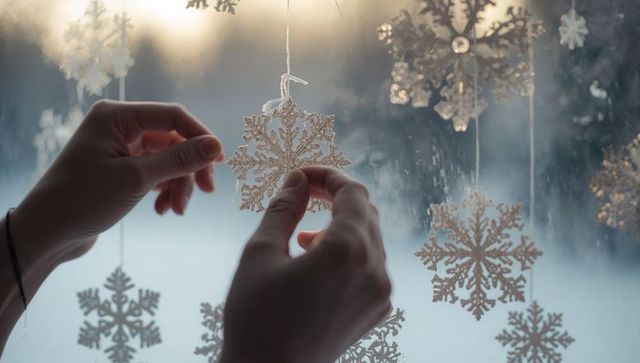 Decorating window with snowflake ornaments for winter elegance