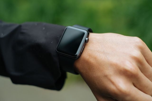 The person is wearing a smartwatch with a black band on their wrist, suggesting an active and modern lifestyle. Ideal for use in technology blogs, fitness and health websites, smartwatch reviews, or promotional content for wearable devices.