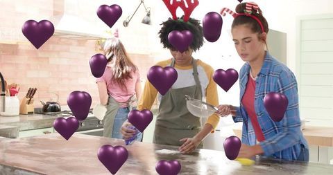 Festive friends baking together in bright kitchen wearing holiday headbands and aprons
