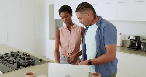 Diverse Couple Planning with Laptop in Modern Kitchen