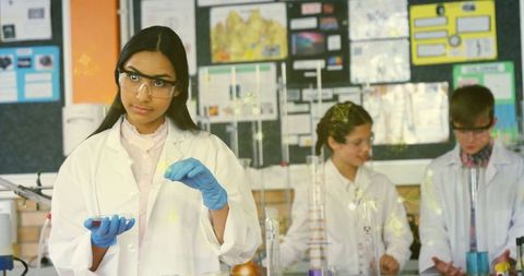 Teenage girl conducting scientific experiment in classroom laboratory