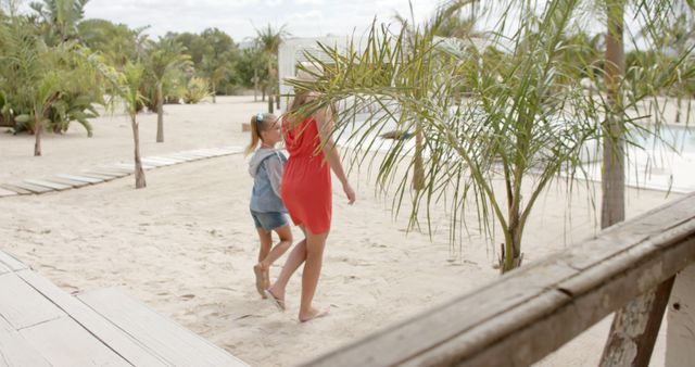 Happy caucasian mother with daughter walking and holding hands at beach house. Vacation, free time, summer and family.